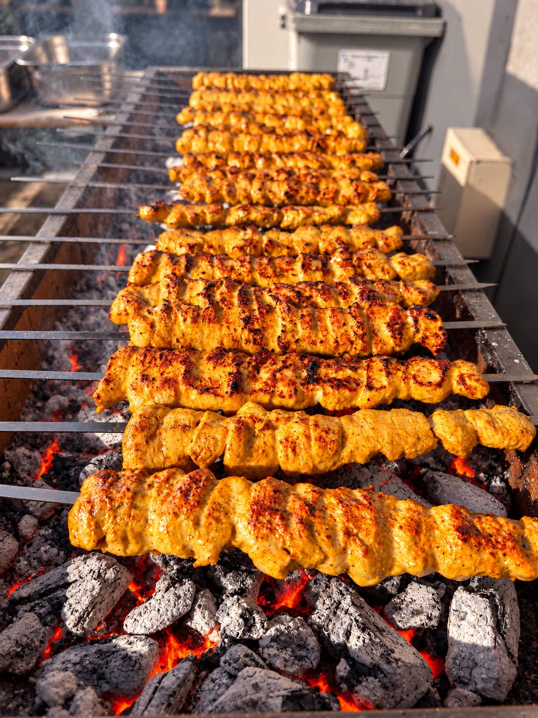 Saffron chicken kebab skewers on the charcoal grill during a Zagros Catering wedding service