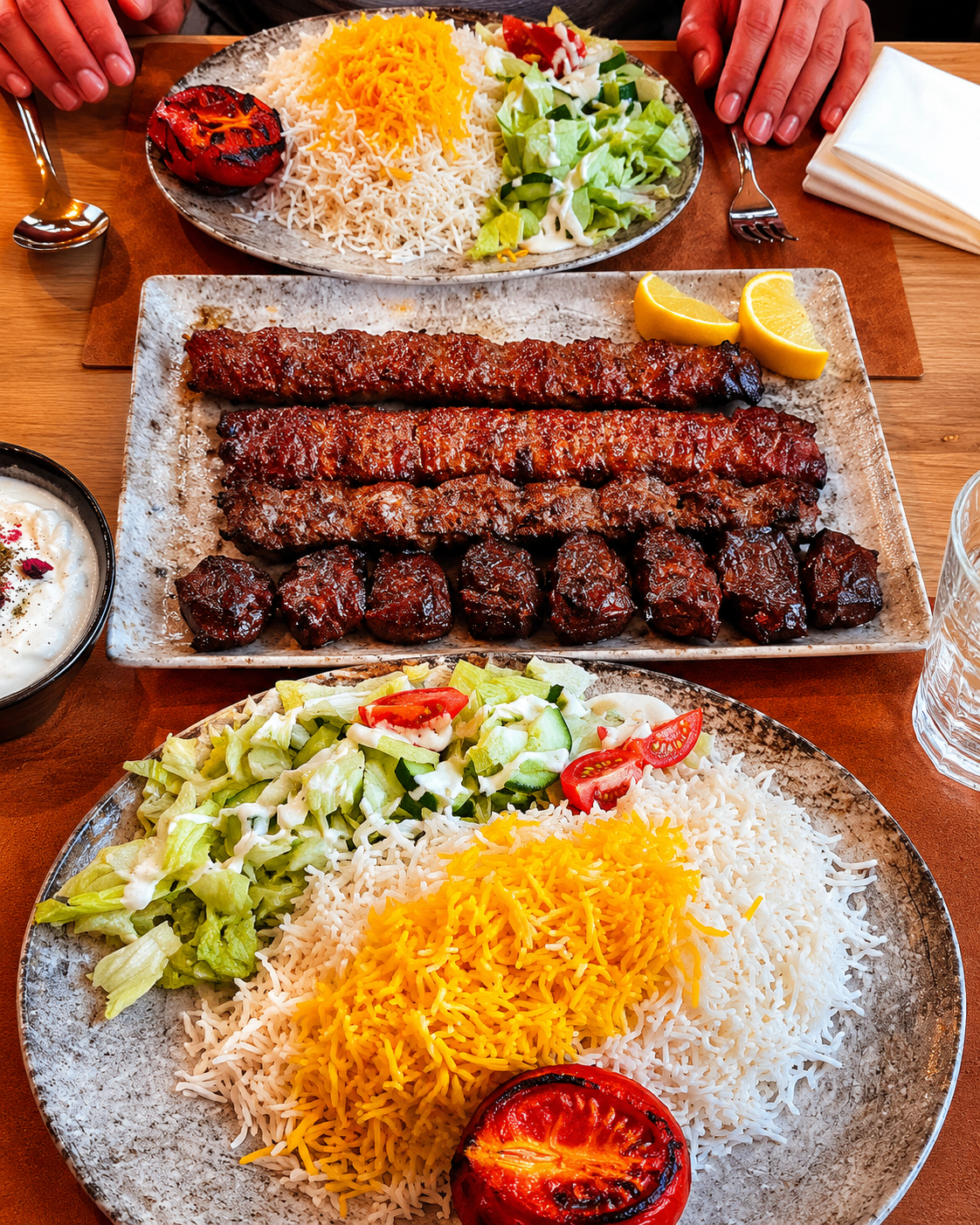 A premium Persian grill platter with saffron rice, salads, and grilled meats at Zagros